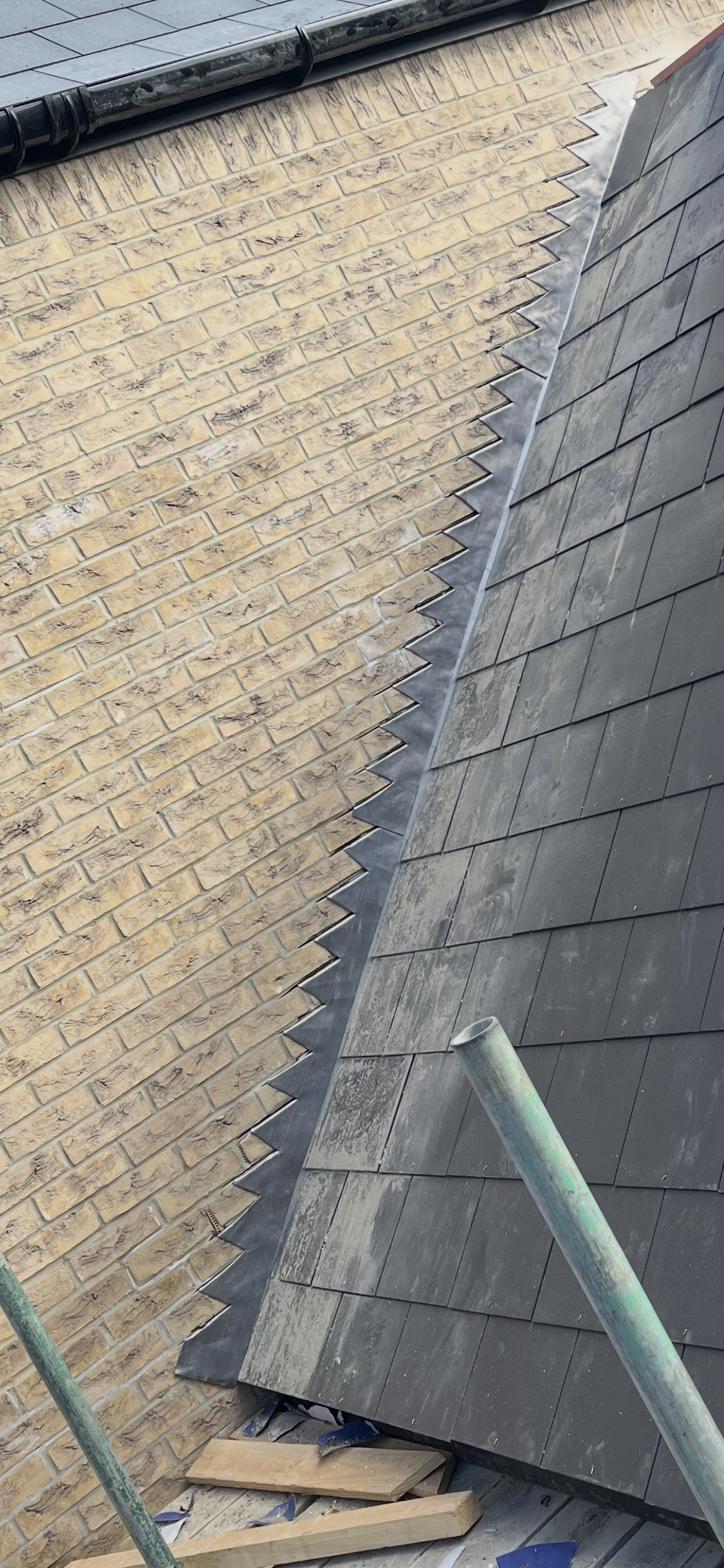 Slates finished neatly against a brick wall