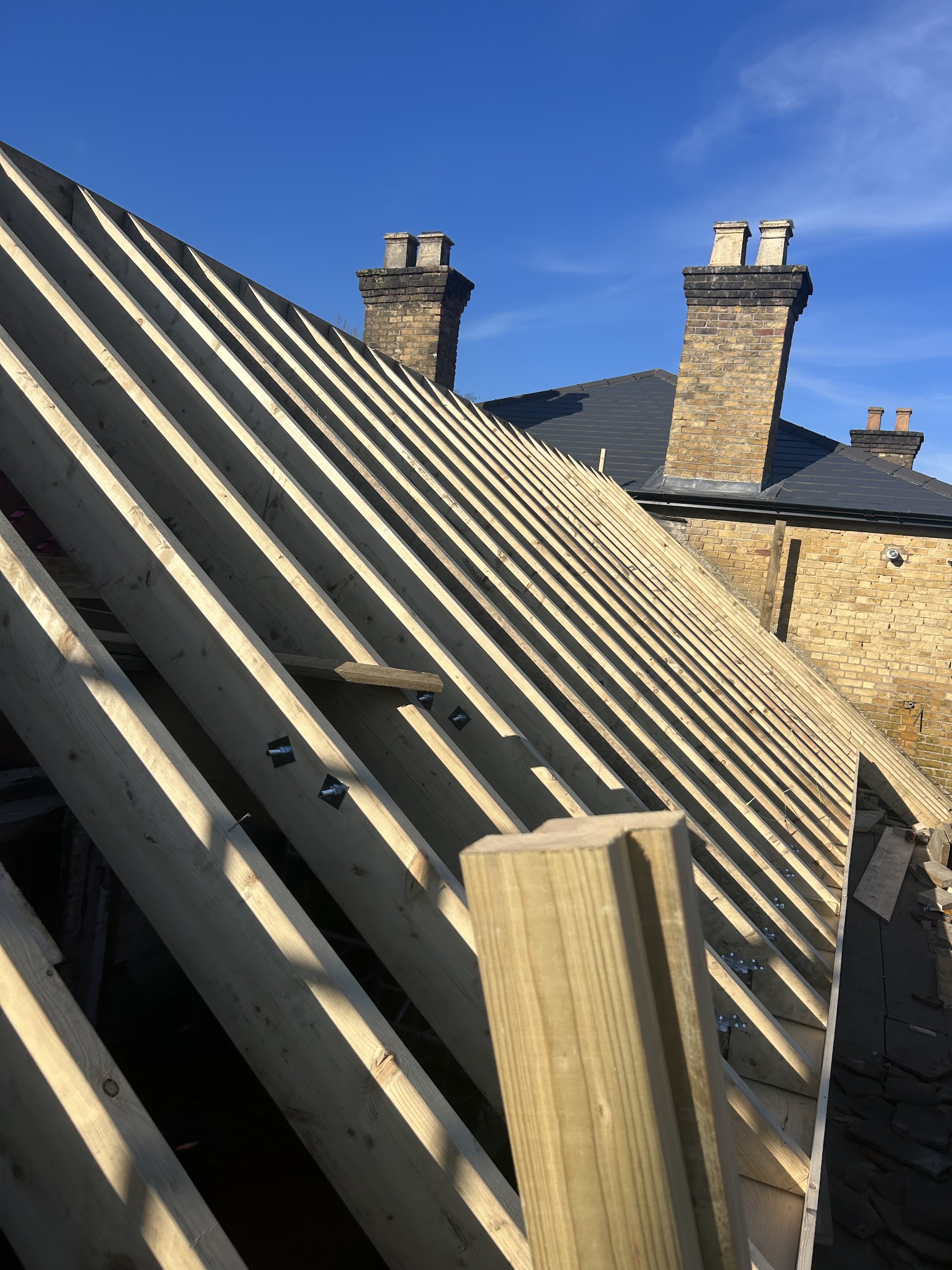 New rafters on a roof under a blue sky