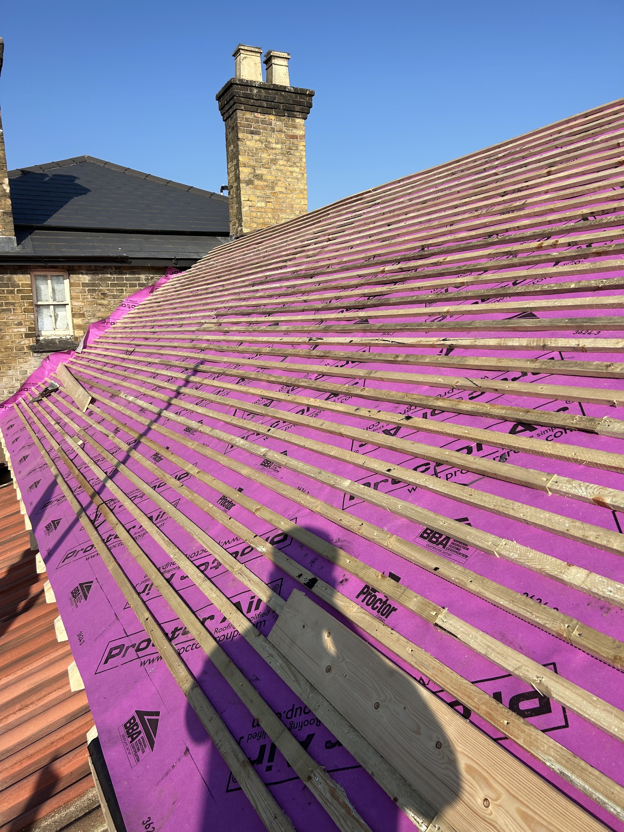 A re-roof in progress with new breathable membrane, battens and a chimney stack
